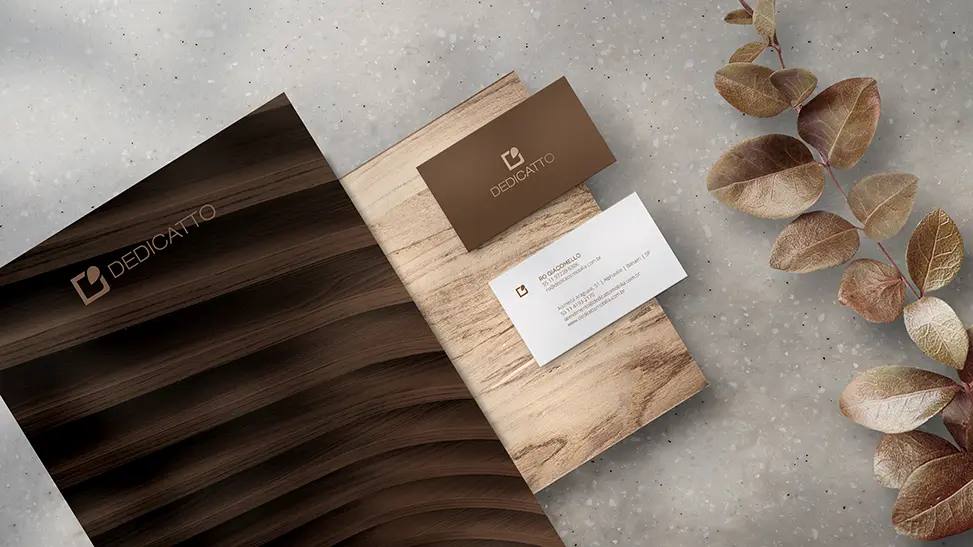 Sistema de marca Dedicatto: papelaria e materiais em tons amadeirados que traduzem a essência da empresa